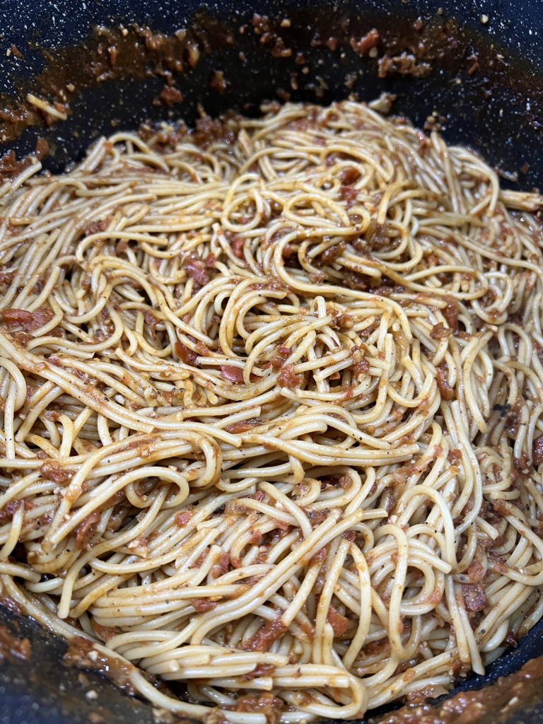 spaghetti noodles mixed with sauce in pot