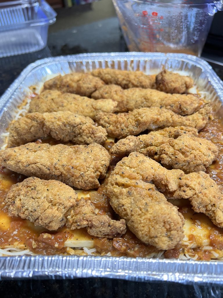chicken on top of a baked spaghetti