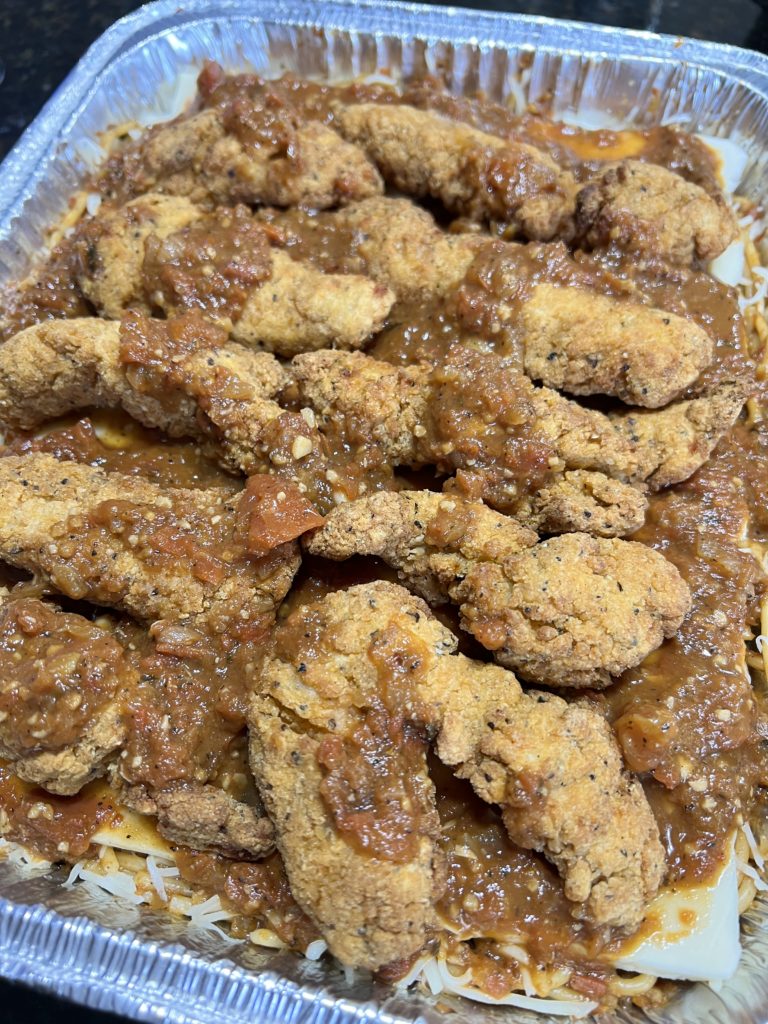 chicken on top of a baked spaghetti